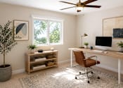 Thumbnail 3 of 7 - A room with a desk, chair, and a plant.