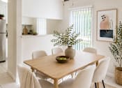 Thumbnail 2 of 9 - A dining room with a table and chairs.
