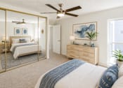Thumbnail 1 of 9 - A bedroom with a large bed and a ceiling fan.
