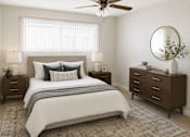 Thumbnail 4 of 14 - A bedroom with a large bed, two nightstands, and a ceiling fan.