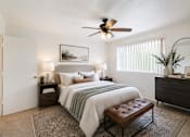 Thumbnail 4 of 9 - A bedroom with a bed, a bench, and a ceiling fan.