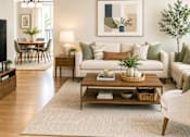 Thumbnail 5 of 14 - A living room with a white couch, a coffee table, and a painting on the wall.