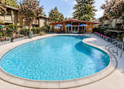 Thumbnail 6 of 10 - A swimming pool surrounded by a fence and trees.