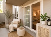 Thumbnail 4 of 9 - A cozy outdoor seating area with a chair, a table, and a potted plant.