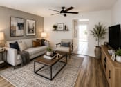 Thumbnail 1 of 11 - A living room with a white couch, a coffee table, and a ceiling fan.
