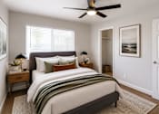 Thumbnail 4 of 11 - A bedroom with a large bed and a ceiling fan.