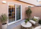 Thumbnail 6 of 11 - A patio with a table, chairs, and plants.