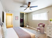 Thumbnail 2 of 6 - A bedroom with a bed, chair, and a ceiling fan.