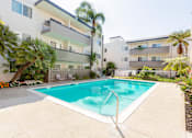 Thumbnail 6 of 9 - A swimming pool in front of a white apartment building.