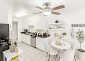 Thumbnail 6 of 12 - A modern kitchen with a dining table and chairs.