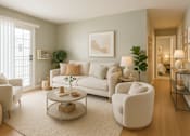 Thumbnail 5 of 12 - A living room with a white sofa, a coffee table, and a potted plant.