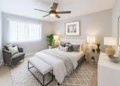 Thumbnail 4 of 12 - A bedroom with a large bed, a chair, and a ceiling fan.