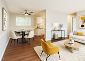 Thumbnail 2 of 8 - A living room with a yellow chair and a white couch.