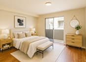 Thumbnail 4 of 11 - A bedroom with a bed, nightstands, and a plant.