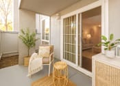 Thumbnail 5 of 9 - A patio with a chair, table, and potted plants.