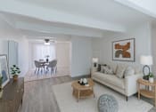 Thumbnail 5 of 10 - A living room with a white couch, a dining table with chairs, and a ceiling fan.