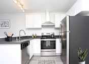 Thumbnail 3 of 10 - A modern kitchen with stainless steel appliances and white cabinets.