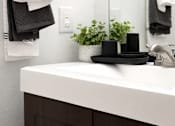 Thumbnail 5 of 14 - A bathroom with a white sink and towels hanging on the wall.
