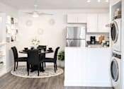 Thumbnail 2 of 14 - A modern kitchen with a dining table set for four.