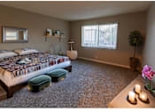 Thumbnail 3 of 5 - a bedroom with a bed and a table with a cat on it