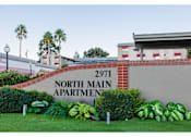 Thumbnail 1 of 5 - A sign for North Main Apartment 2971 is displayed in front of a building.