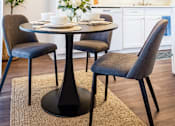 Thumbnail 2 of 9 - A dining room with a table and chairs.