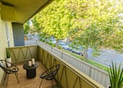 Thumbnail 5 of 10 - A balcony with a table and chairs overlooking a street.