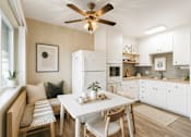 Thumbnail 3 of 5 - A modern kitchen with a dining table and chairs.