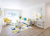 Thumbnail 1 of 9 - A living room with a yellow chair and a white couch.