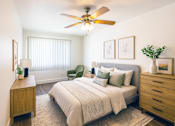 Thumbnail 3 of 13 - A bedroom with a bed, nightstand, and chair.