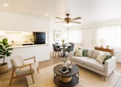 Thumbnail 1 of 13 - A living room with a couch, chairs, and a dining table.
