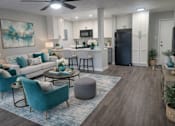 Thumbnail 3 of 12 - A living room with a dining table set up with chairs around it.