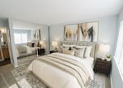Thumbnail 1 of 11 - A bedroom with a large bed and a painting on the wall.