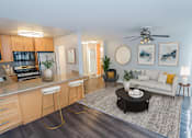 Thumbnail 2 of 11 - A modern kitchen with a bar stool and a coffee table.