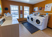 Thumbnail 7 of 8 - A laundromat with a washer and dryer and a payment machine.