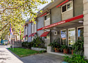 Thumbnail 1 of 6 - The front of a building with a red awning that says City Park Apartment Homes.