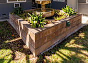 Thumbnail 6 of 6 - A courtyard with a fountain and a wall.