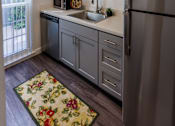 Thumbnail 2 of 7 - A kitchen with a refrigerator, sink, and cabinets.