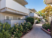 Thumbnail 5 of 8 - A white building with a garden in front.