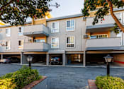 Thumbnail 7 of 8 - A parking garage in front of a multi-story apartment building.