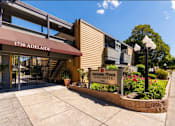 Thumbnail 7 of 7 - The front of the Melalade Fines Apartments building is shown with a clear blue sky in the background.