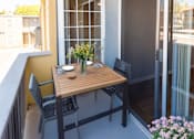 Thumbnail 4 of 7 - A balcony with a table and chairs.