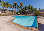 Thumbnail 4 of 9 - a swimming pool with palm trees and buildings in the background