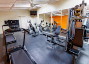 Thumbnail 5 of 9 - a gym with cardio equipment and weights on the floor