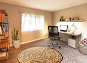 Thumbnail 3 of 7 - A room with a desk, chair, and a window with blinds.