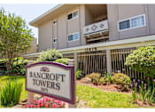 Thumbnail 1 of 8 - A sign for Bancroft Towers stands in front of a building.