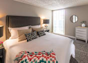 Thumbnail 1 of 8 - A bedroom with a large bed and a nightstand.