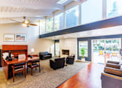 Thumbnail 7 of 8 - A living room with a fireplace and a ceiling fan.