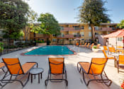 Thumbnail 6 of 8 - A pool surrounded by orange chairs and tables.