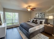 Thumbnail 2 of 8 - A bedroom with a large bed and a ceiling fan.
